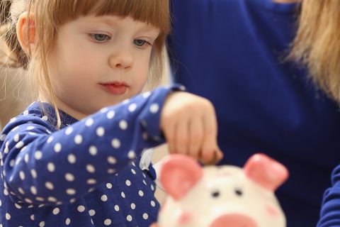 Foto: Kind mit Sparschwein